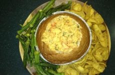 Crawfish Au Gratin dip in Bread Bowl with corn chips and pickled okra