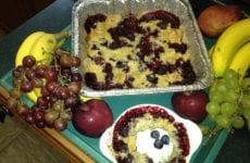 Blackberry Cobbler presented with fruit and a bowl dished up.