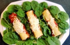 Plate of Alice's Spinach Manicotti on a bed of greens