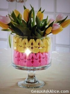 Vase lined with peep bunnies with a flower arrangement.