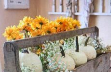 Old wooden tool box beautiful with pumpkins and flowers.